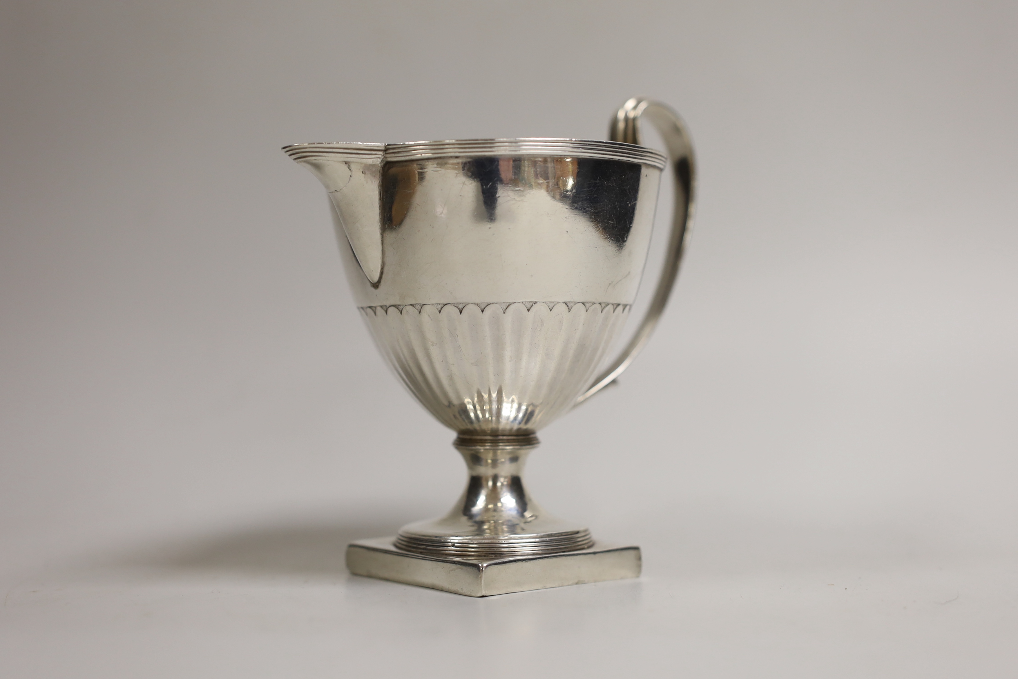 A George III demi-fluted vase shaped pedestal cream jug, Henry Chawner, London, 1791, height 13cm, 8.1oz.